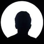 Artistic silhouette of an unknown person against a bright circular light background.